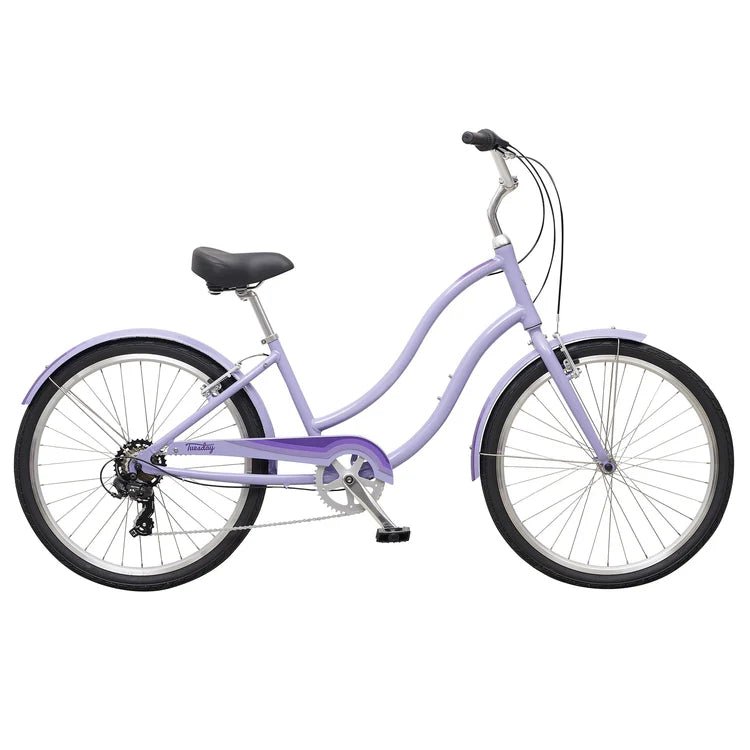 Lavender step-through cruiser bicycle – This Tuesday March 7 LS cruiser bicycle features a light lavender step-through frame, matching fenders, swept-back handlebars, and a black saddle, shown in profile against a plain white background.