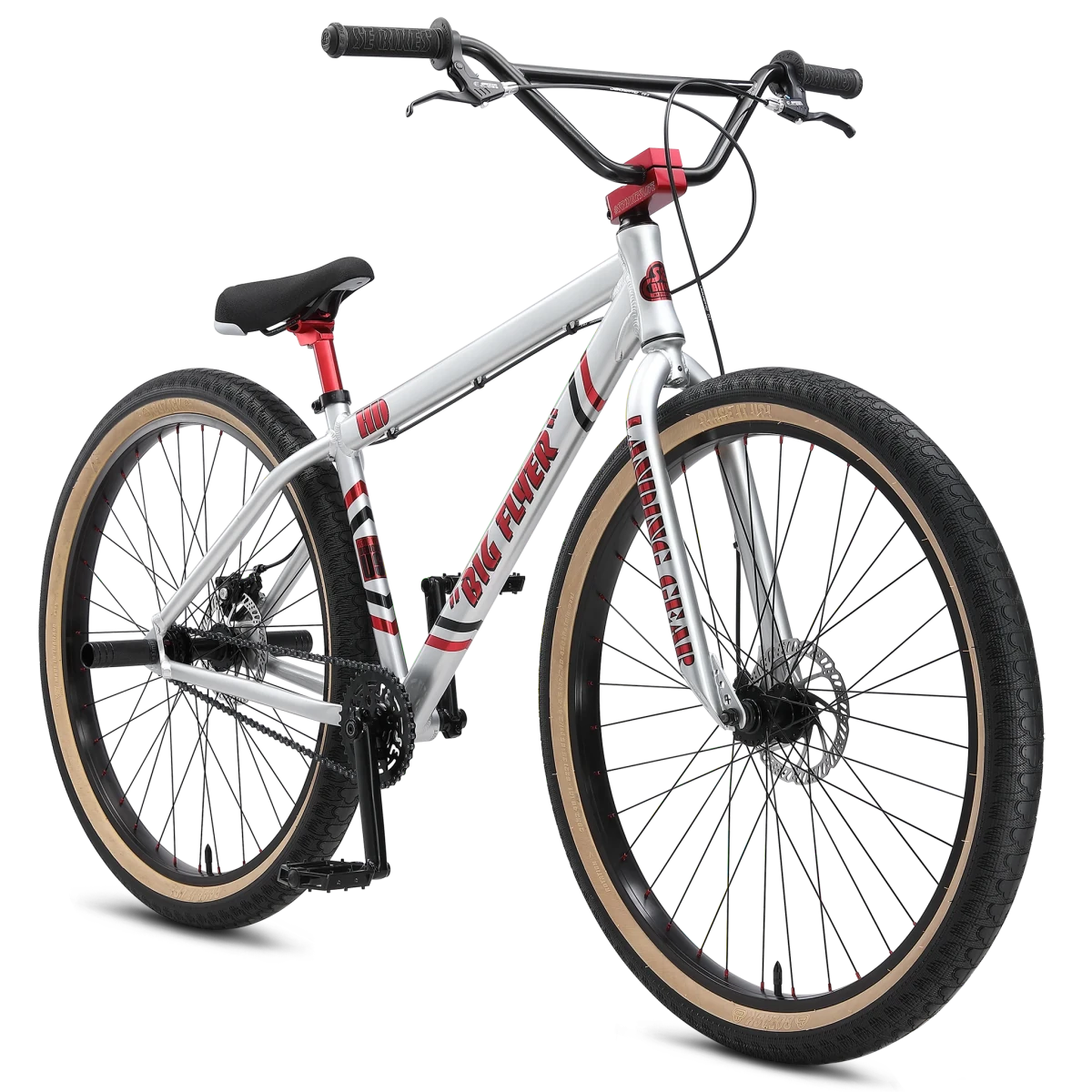 SE Big Flyer HD 29-inch wheelie bike – A silver cruiser bicycle with red graphics, black handlebars, disc brakes, and tan-wall tires is shown from a three-quarter angle against a white backdrop.