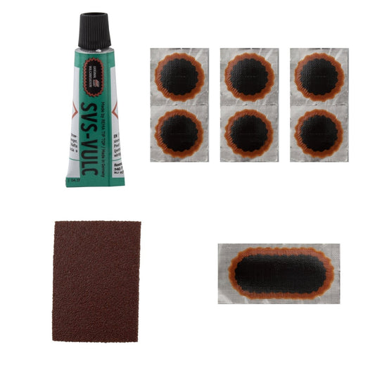 Rema Tip Top bicycle patch kit contents – A green tube of vulcanizing fluid, brown sandpaper, six round tire patches, and one large oval patch are neatly arranged against a plain white background.