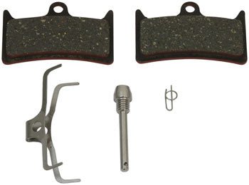 Hope V4 standard compound brake pads – A pair of textured dark grey bicycle disc brake pads rests on a white background alongside a metal spreader spring, threaded retaining pin, and safety clip.