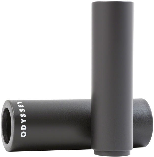 Black Odyssey Joystick PC BMX peg – Matte black cylindrical BMX peg with white Odyssey branding lies horizontally behind an upright matching alloy core cylinder, set against a plain white background.