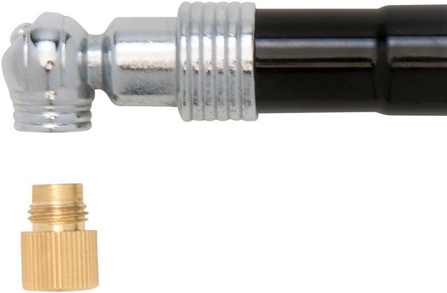 Bicycle pressure gauge head with brass adapter – A close-up view shows the chrome nozzle and black barrel of a bike tire pressure gauge positioned horizontally above a separate small brass screw adapter.