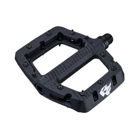 Black RaceFace Chester composite platform pedal – Angled view of a matte black composite bicycle platform pedal featuring steel traction pins, a threaded axle spindle, and a white brand logo on a plain white background.