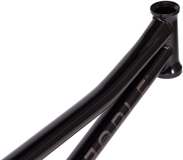 Gloss black BMX bike frame headtube detail – A close-up view shows the glossy black steel headtube, curved top tube, and down tube with subtle branding on a BMX bike frame against white.