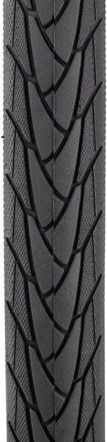 Schwalbe Marathon Plus tire tread pattern – Close-up of a black rubber bicycle tire tread showcasing deep directional sipes, textured shoulders, and a central ridge against a plain white background.