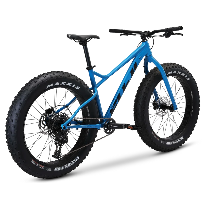 Fuji Wendigo 1.1 blue fat bike – A bright blue all-terrain fat bike with oversized knobby Maxxis tires, black disc brakes, and a rigid front fork, shown from a rear three-quarter studio view against a white background.