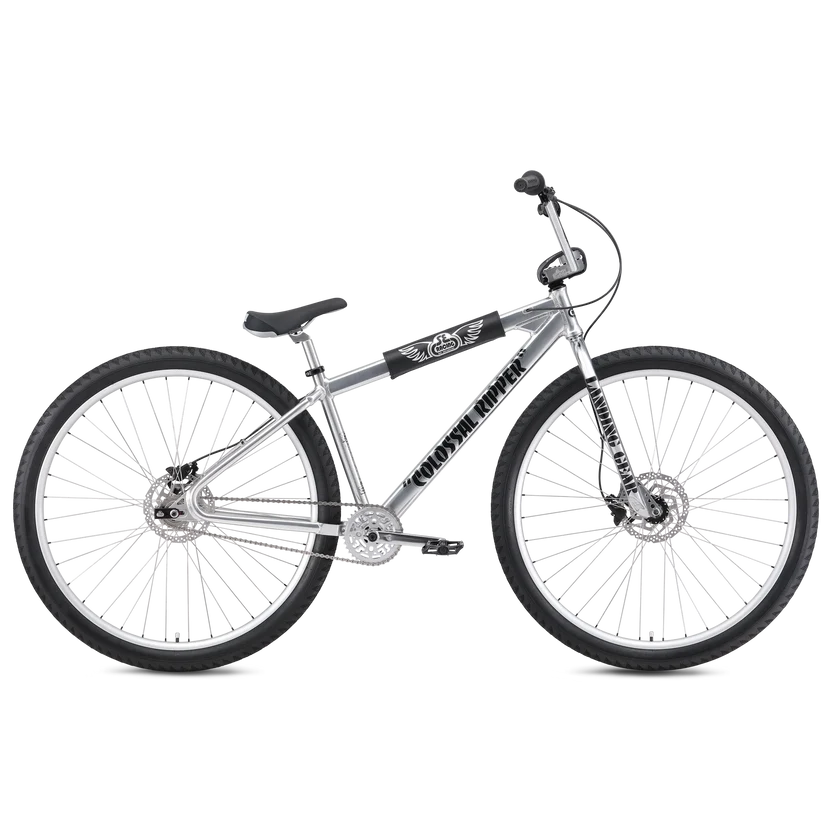 Silver SE Colossal Ripper 32 BMX cruiser – A polished silver BMX cruiser bike with oversized 32-inch wheels, black accents, front and rear disc brakes, and branded frame padding, shown against a white background.