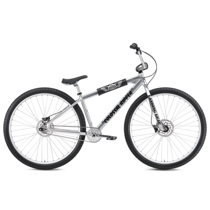 Silver SE Colossal Ripper 32 BMX cruiser – A polished silver BMX cruiser bike with oversized 32-inch wheels, black accents, front and rear disc brakes, and branded frame padding, shown against a white background.