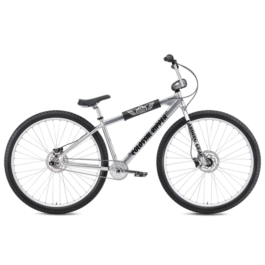 Silver SE Colossal Ripper 32 BMX cruiser – A polished silver BMX cruiser bike with oversized 32-inch wheels, black accents, front and rear disc brakes, and branded frame padding, shown against a white background.