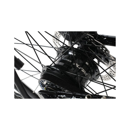Shimano Alfine hub on folding bike – Close-up view of a black Shimano Alfine internal gear hub with belt drive cog, spoke-laced wheel, and disc brake rotor against white background.