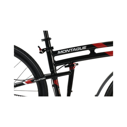 Montague Allston folding bike frame close-up – A close-up view of a glossy black bicycle frame with red and white accents, highlighting the Montague logo, folding mechanism hinge, and seat tube.