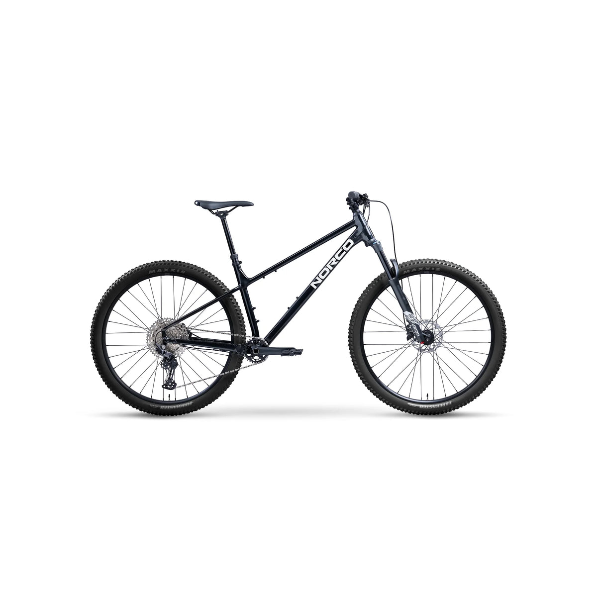 Norco Charger 2 hardtail mountain bike – A dark metallic blue Norco hardtail mountain bike is displayed in a side profile studio shot with knobby Maxxis tires, front suspension, and a black saddle.