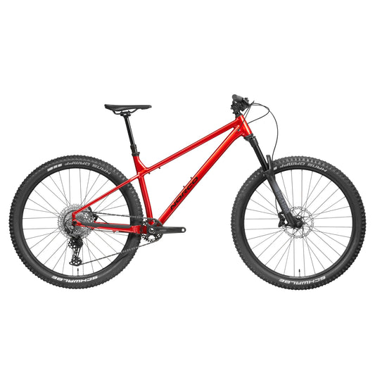 Norco Torrent A1 hardtail mountain bike – Side profile of a red aluminum hardtail trail mountain bike with black RockShox suspension fork, knobby 29-inch Schwalbe tires, and disc brakes, isolated on white.