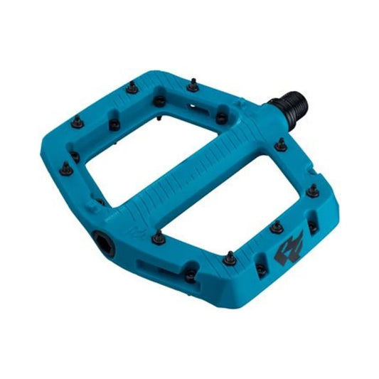 Turquoise RaceFace Chester composite platform pedal – Angled view of a bright turquoise composite mountain bike pedal featuring black steel traction pins and threaded spindle against a plain white background.