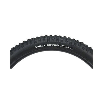 Surly Dirt Wizard tubeless bike tire – The upper curved section of a black Surly Dirt Wizard mountain bike tire features knobby tread and white sidewall branding over a plain background.
