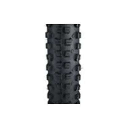 Surly Dirt Wizard knobby bike tire tread – A close-up view shows the aggressive black rubber tread pattern and deep side knobs of a mountain bike tire centered against a white background.